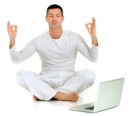 man doing yoga next to laptop